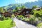 Picturesque Alpine village Wengen in Switzerland in summer season. Mountain chalets, hikers and green hilly landscape. Swiss Alps