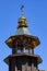 Picturesque bell tower of a wooden Orthodox church with a gilded roof and a cross