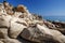 Picturesque big stones on the beach of Vourvourou on the Greek peninsula of Sithonia against the background of the sea and blue sk