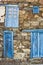 Picturesque blue grunge doors and windows. Rustic stone wall