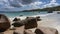 Picturesque boulders lie on the beach at the water\\\'s edge