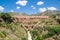 Picturesque bridge set amongst lush green trees and rolling mountains