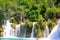 A picturesque cascade waterfall among large stones in the Krka Landscape Park, Croatia in spring or summer. The best big