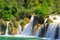 A picturesque cascade waterfall among large stones in the Krka Landscape Park, Croatia in spring or summer. The big beautiful