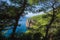 Picturesque cliff and deep blue water of Mediterranean sea photo framed in pine trees, Nature