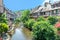 A picturesque colorful view of half-timber buildings at a small creek in the village of Kaysersberg in Vosces region