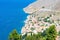 Picturesque detailed bird`s eye view on tiny colorful houses on rocks on shore of Mediterranian sea on Greek island in sunny summ