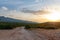 Picturesque dirt road against the backdrop of sunset and mountains. Croatia.