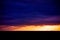 Picturesque dramatic panorama of sunset sky over dark flat skyline
