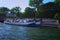 The picturesque embankment of the Seine River with residential barges during sunset. View from tourist boat. Paris, France