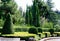 Picturesque example of topiary art with evergreens. Geometric figures from evergreens against background of cypresses, cedars