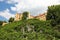 The picturesque foothills of the Alps, the lake surrounded with the low rocks overgrown with the dense wood are visible the old ca