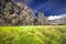 Picturesque grassy field with a large stone wall in the background and a cloudy sky overhead