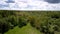 Picturesque green forestry area around small meadow under blue sky