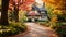 A picturesque house surrounded by vibrant trees and a carpet of fallen leaves during the fall season, A pathway lined with fall