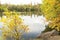 Picturesque image of autumn lake with reflection of red, yellow, green trees in tranquil water.