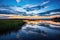 A picturesque lake with sparkling water nestled amidst a breathtaking natural backdrop, A peaceful marsh at dusk with reflections