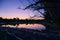 Picturesque lakeshore with tree branches in Moos during sunset, Bavaria, Germany