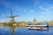 The picturesque landscape with aerial mills and boat on the channel in Kinderdiyk, Netherlands