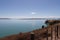 Picturesque landscape with dry grass slope, blue sea and mountains on background in a sunny day, Duder Regional Park, Auckland