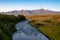 Picturesque Landscape of Iceland With A Tree Lined River, Open Meadow and Snow Capped Mountains