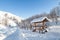 The picturesque landscape with snowdrifts, a hiking trail along the fence with a wooden gazebo in the Altai mountains under a blue