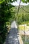 Picturesque metal suspension cable bridge over the river in the mountains