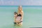 A picturesque moment: a pregnant woman and her son enjoying the turquoise sea, a heartwarming family bond by the