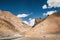 Picturesque mountain landscape on the endless Leh - Manali road. Blue sky with white clouds and desert lifeless rocky mountains.