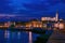 Picturesque nightscape of coastline of Adriatic sea with illuminated houses and lighthouse at twilight, Piran, Slovenia