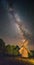 Picturesque nightscape of starry sky with Milky Way above an old wooden windmill