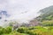 Picturesque paddy rice terraces and village houses in Jinkeng, Longji, Guangxi, China in a foggy and cloudy day with occasional