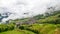 Picturesque paddy rice terraces and village houses in Jinkeng, Longji, Guangxi, China in a foggy and cloudy day with occasional