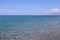 Picturesque panorama of the clear blue sea and the sea coast on a clear sunny summer day, Sailboat on the horizon, calm.