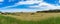 Picturesque panorama landscape of countryside field with straw b