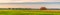 Picturesque panoramic summer landscape with beveled meadow and haystacks in cloudy morning. Hay harvest at farmland. Beautiful
