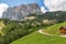 A picturesque path through an alpine meadow in the Italian Dolomites for hiking and cycling. Italian Alps