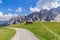 A picturesque path through an alpine meadow in the Italian Dolomites for hiking and cycling. Italian Alps