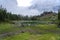 Picturesque peaks of Dolomites mountains in reflection of crystal clear pond surrounded by coniferous forest. Lake of Caresse in