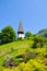 Picturesque Protestant church in Alpine city Wengen, Switzerland photographed in the summer with green landscape and colorful