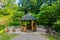 A picturesque recreation area with a wooden pergola with a green roof and benches on the sides.