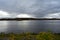 A picturesque river. Autumn forest near the village. Motor ship, buoy. Clouds