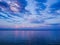 Picturesque river landscape. Sunny sunset. Pink clouds on the blue sky. Sailboat on the horizon