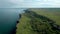 Picturesque rocky coastline with green fields and trees