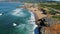 Picturesque rocky sea coast aerial view. Ocean waves splashing in slow motion