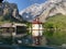 Picturesque rural scene featuring quaint building situated on the edge of a tranquil lake Konigssee