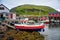 Picturesque scene fishing boats, boathouses and green mountain background, Kamoyvaer Village, Mageroya Island, Norway