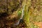 A picturesque small Raduzhnyi waterfall in the suburbs against the backdrop of bright autumn nature on the left bank of the Nara