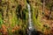 A picturesque small Raduzhnyi waterfall in the suburbs against the backdrop of bright autumn nature on the left bank of the Nara