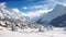 A picturesque snow-covered mountain stands tall as a charming village sits peacefully in the foreground., Panoramic view of